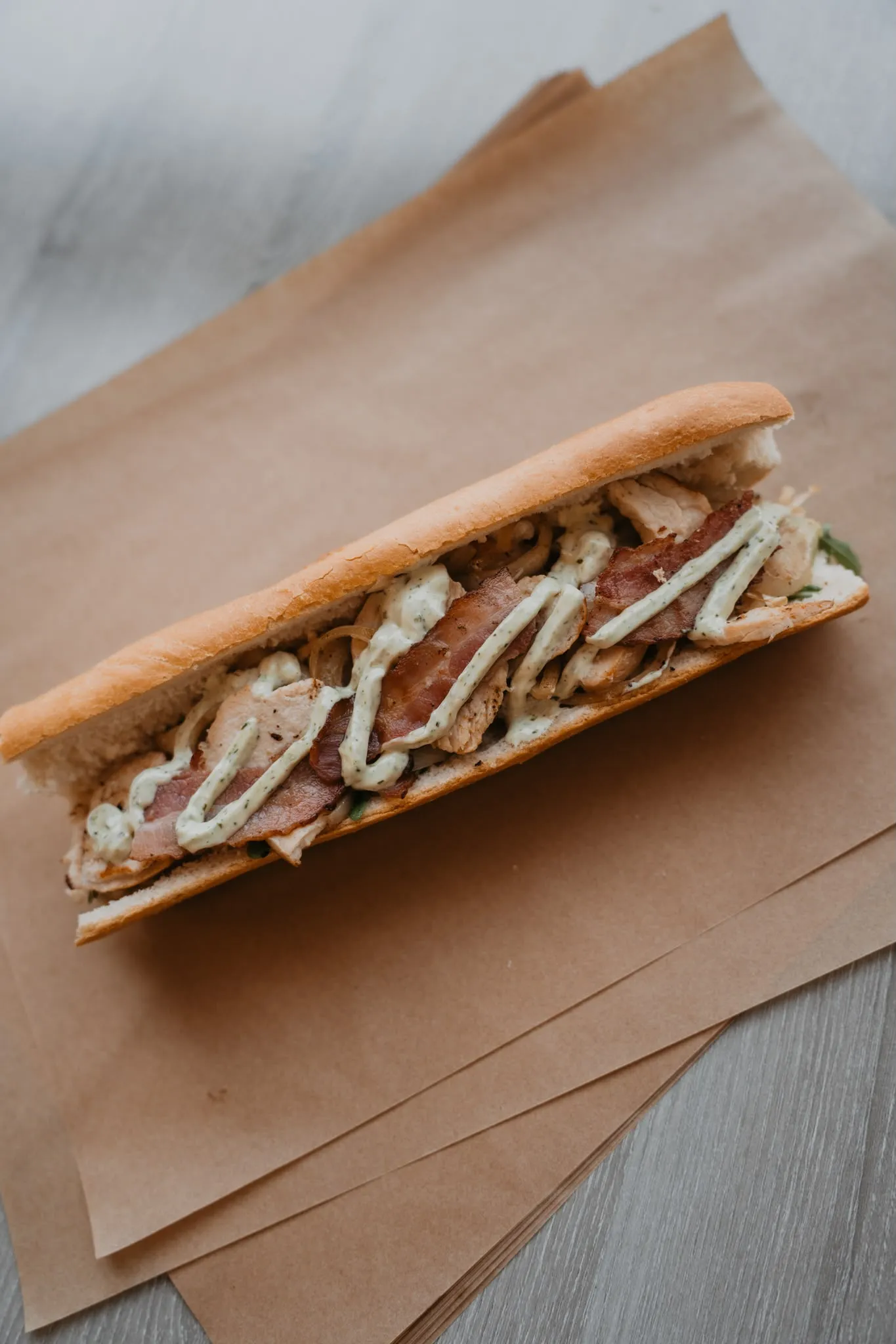 Vers belegd broodje Chapeau met gegrilde kip, bacon en pestomayonaise, dagvers gemaakt bij broodjeszaak Chapeau in Tilburg