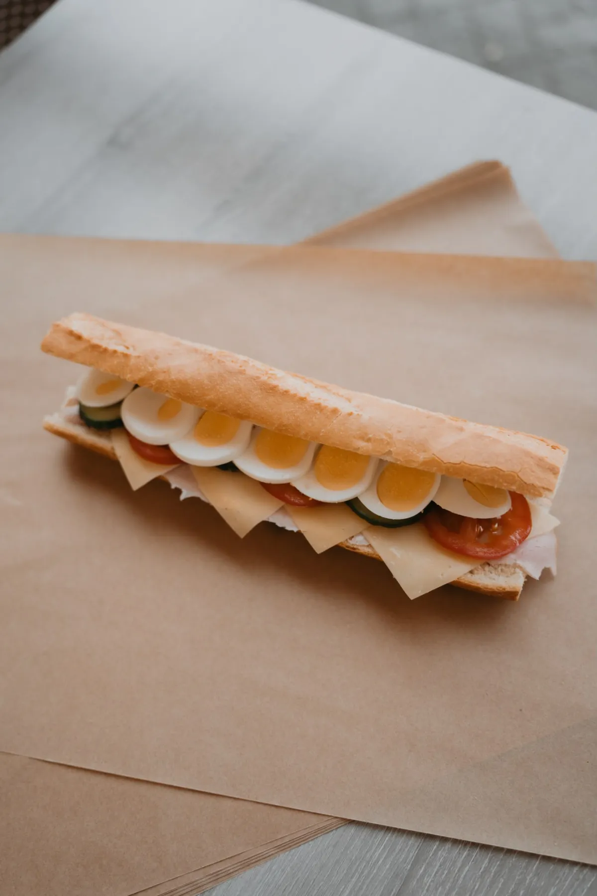 Broodje gezond met ham, kaas, ei, komkommer en tomaat op vers afgebakken stokbrood bij Chapeau Tilburg